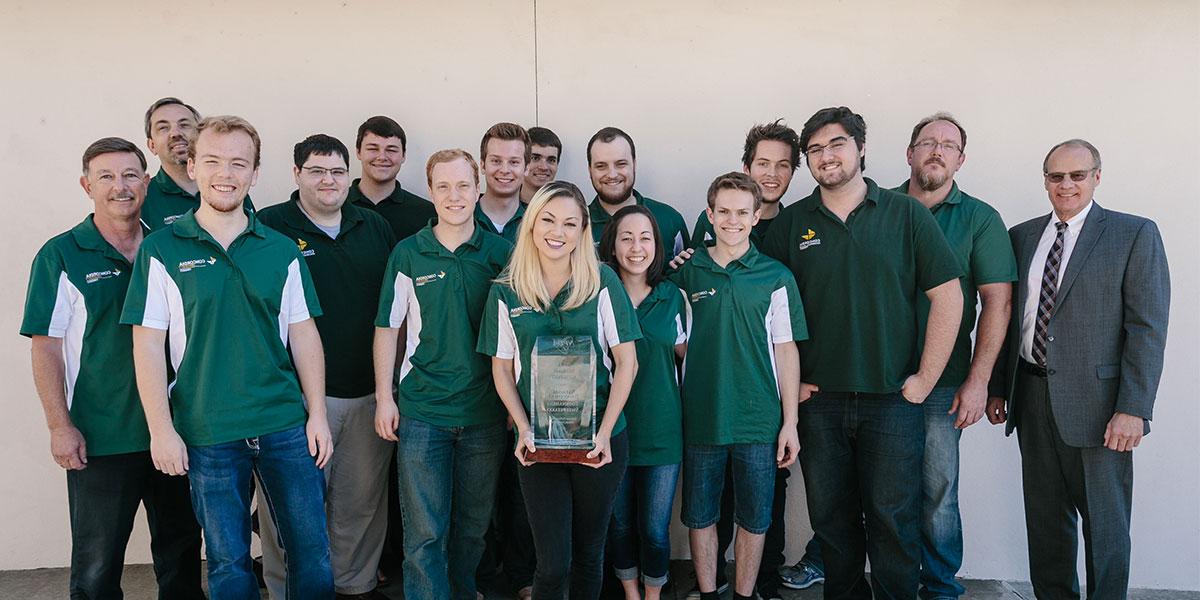 Debate Team standing with trophy